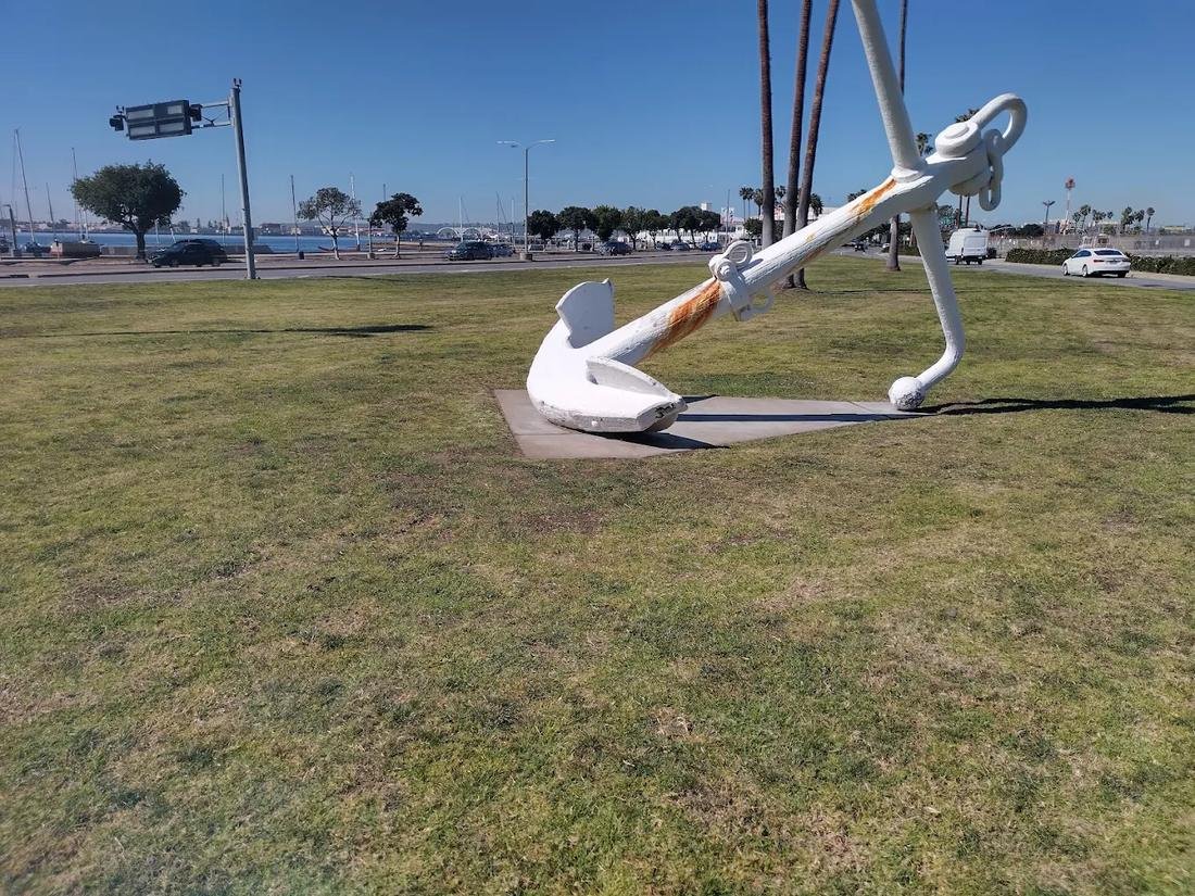 Freshly mowed waterfront park lawn with anchor monument
